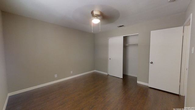 unfurnished bedroom featuring dark hardwood / wood-style flooring, a closet, and ceiling fan