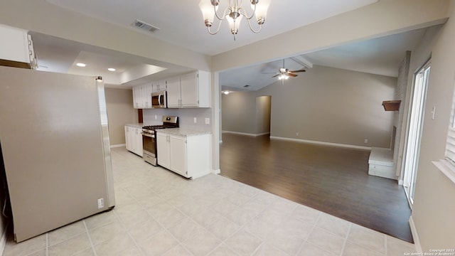 kitchen with vaulted ceiling with beams, white cabinetry, stainless steel appliances, light stone countertops, and ceiling fan with notable chandelier