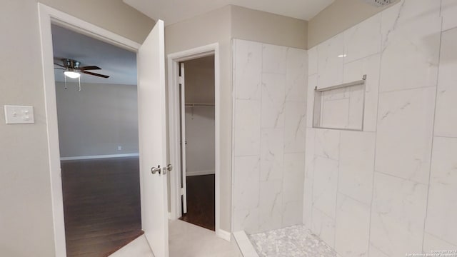 bathroom with tiled shower and ceiling fan