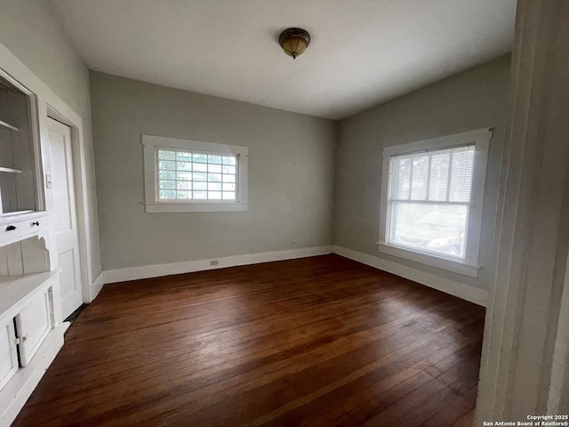 spare room with dark hardwood / wood-style floors