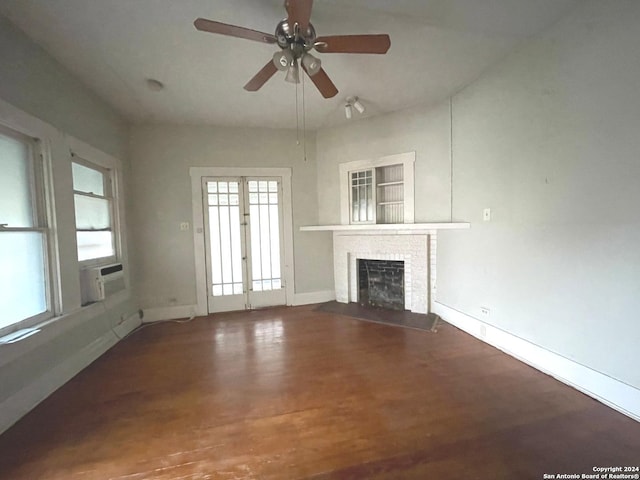 unfurnished living room with ceiling fan, wood-type flooring, and a brick fireplace