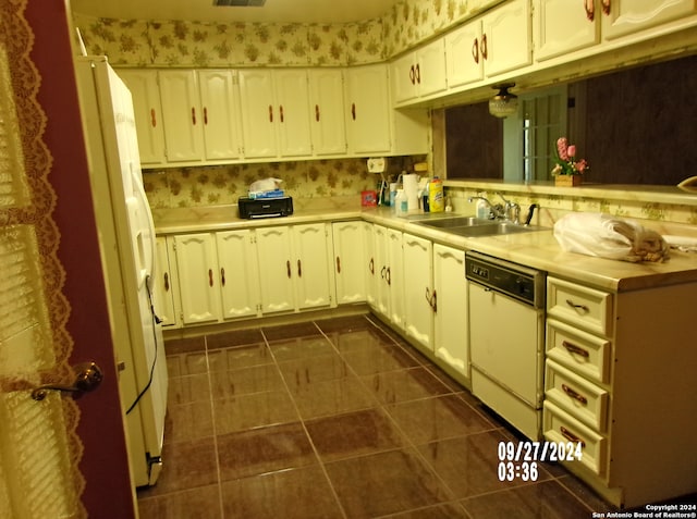 kitchen featuring sink, dark tile patterned floors, white appliances, and white cabinets