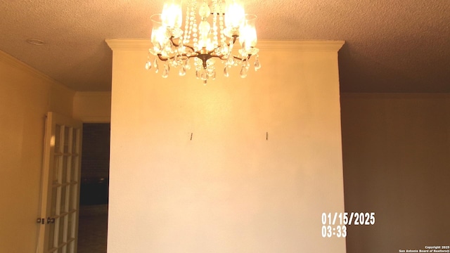 details with a textured ceiling, a chandelier, and ornamental molding
