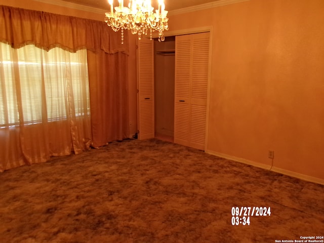 carpeted spare room featuring crown molding and a chandelier