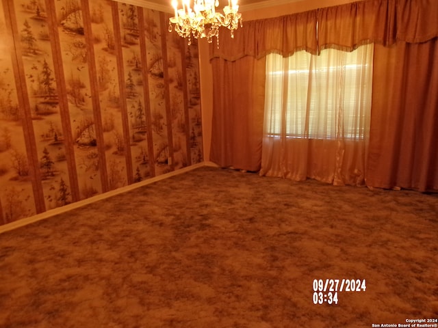 empty room with carpet flooring and a chandelier