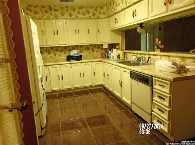 kitchen with white appliances, light countertops, dark tile patterned flooring, and a sink