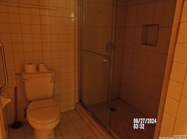 bathroom with toilet, tile patterned floors, and walk in shower