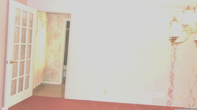 tiled empty room featuring carpet flooring and ornamental molding