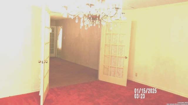 empty room with carpet flooring and a chandelier