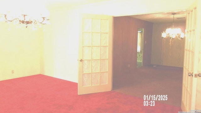 unfurnished room with carpet flooring and a chandelier