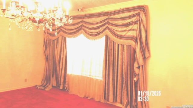 carpeted spare room with baseboards and a chandelier
