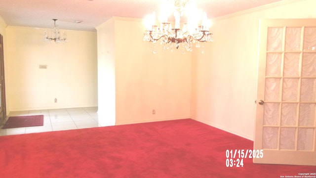 empty room with tile patterned floors, crown molding, baseboards, carpet, and an inviting chandelier