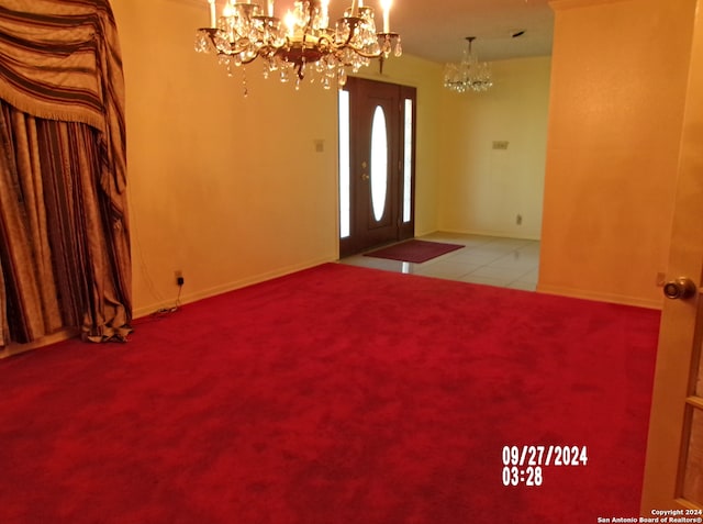 tiled entryway featuring a notable chandelier