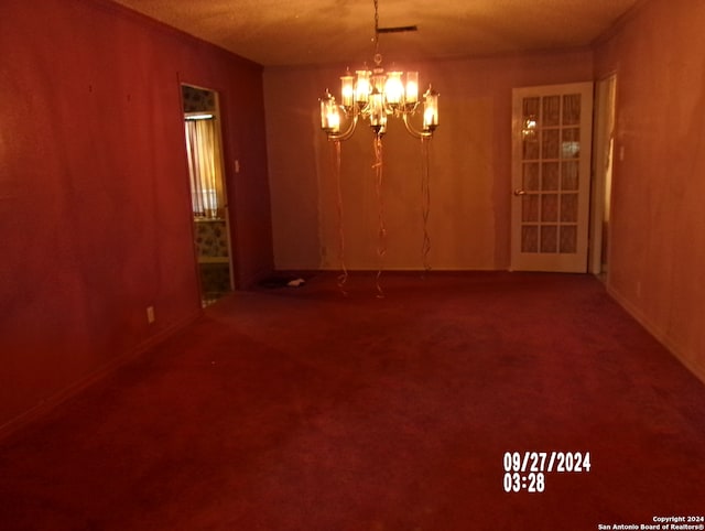 unfurnished room with carpet floors and a notable chandelier