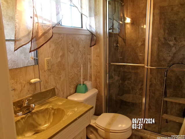 bathroom featuring toilet, an enclosed shower, and vanity