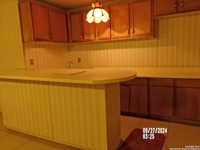 kitchen with kitchen peninsula and light tile patterned floors