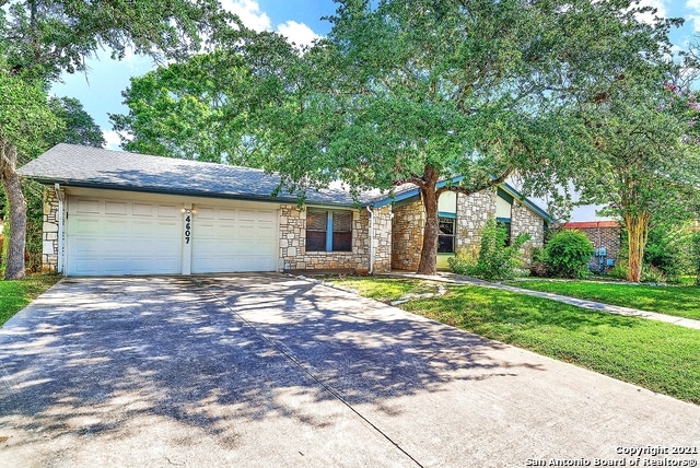 single story home featuring a garage and a front lawn