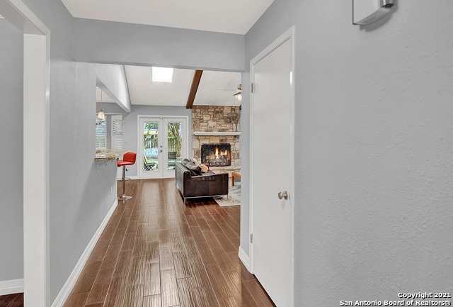 hallway featuring lofted ceiling with beams, dark hardwood / wood-style floors, and french doors