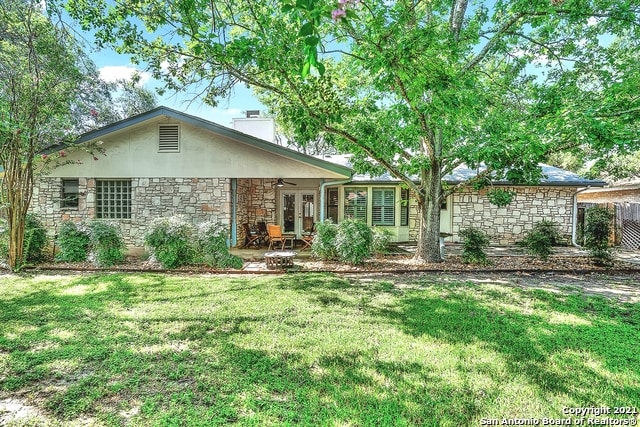 rear view of property featuring a lawn