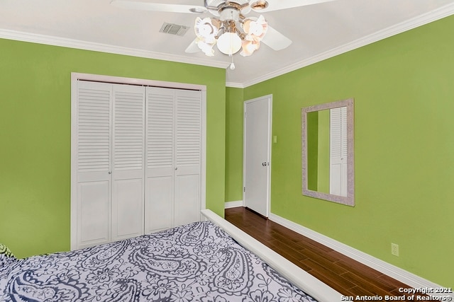 bedroom featuring hardwood / wood-style flooring, crown molding, a closet, and ceiling fan