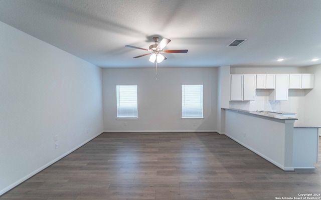 kitchen featuring a textured ceiling, dark hardwood / wood-style flooring, backsplash, ceiling fan, and white cabinets