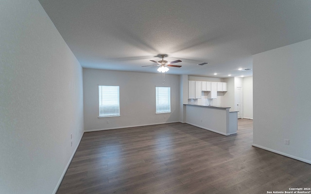 unfurnished living room featuring a textured ceiling, ceiling fan, and dark hardwood / wood-style flooring