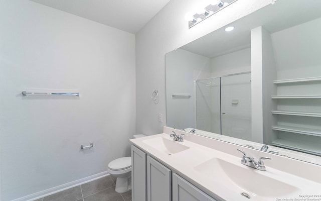 bathroom featuring tile patterned flooring, vanity, toilet, and walk in shower