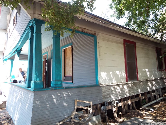 view of side of property featuring covered porch