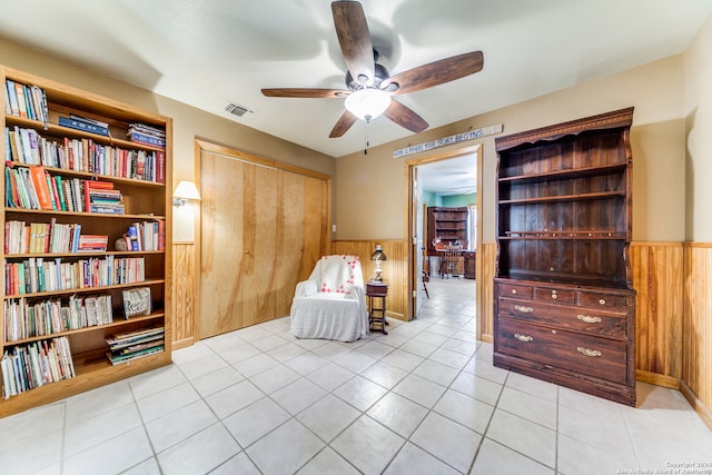 living area featuring light tile patterned floors and ceiling fan