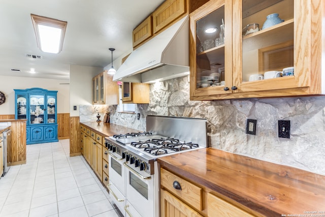 kitchen featuring backsplash, hanging light fixtures, light tile patterned floors, and range with two ovens