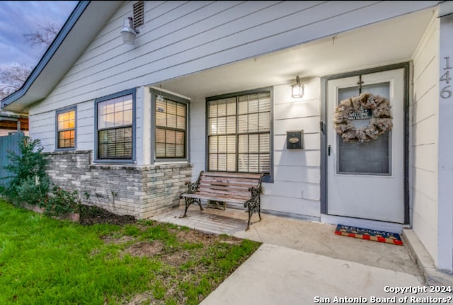 property entrance with a lawn