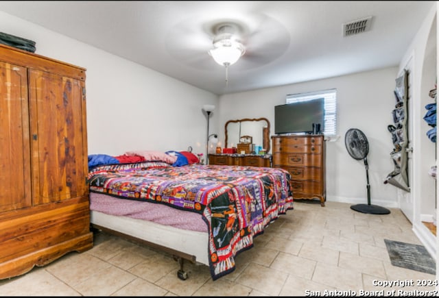 tiled bedroom featuring ceiling fan