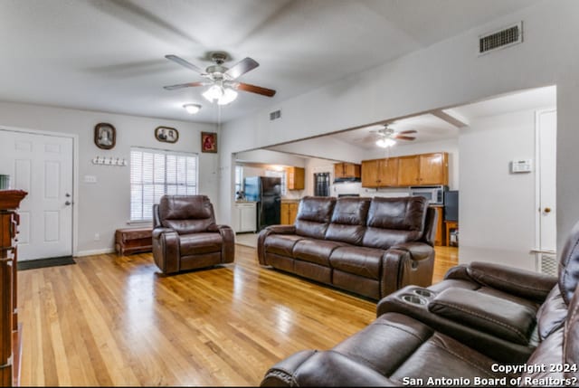 living room featuring light hardwood / wood-style flooring and ceiling fan