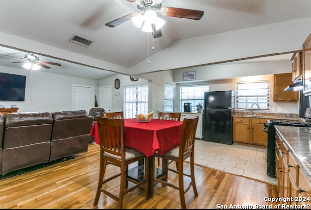 dining area featuring ceiling fan, lofted ceiling, and light hardwood / wood-style flooring