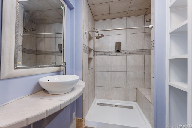 bathroom with tiled shower and sink