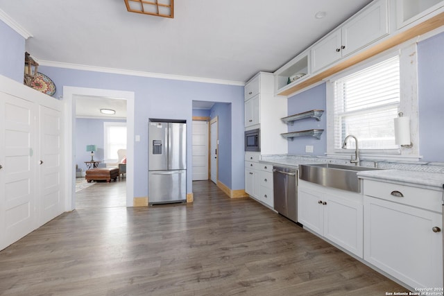 kitchen with white cabinets, appliances with stainless steel finishes, crown molding, and sink