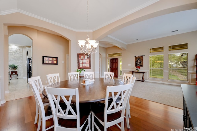 carpeted dining room featuring a chandelier and ornamental molding