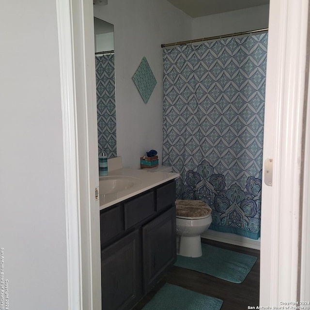 bathroom with toilet, vanity, and curtained shower