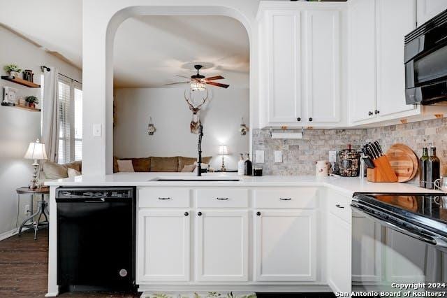 kitchen with kitchen peninsula, sink, white cabinets, tasteful backsplash, and black appliances