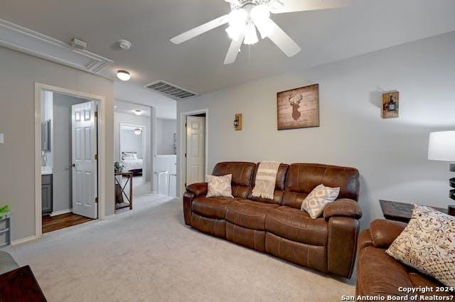 carpeted living room with ceiling fan