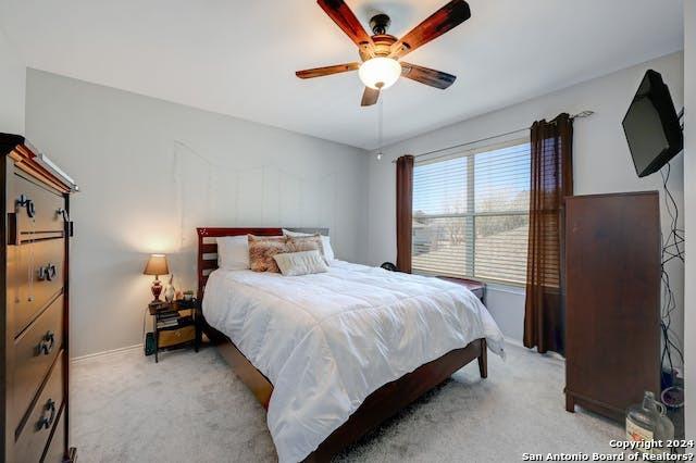 bedroom featuring light carpet and ceiling fan