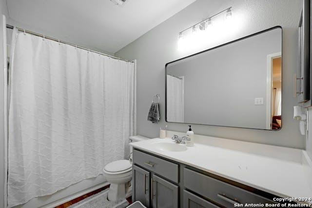 bathroom featuring vanity, toilet, and curtained shower