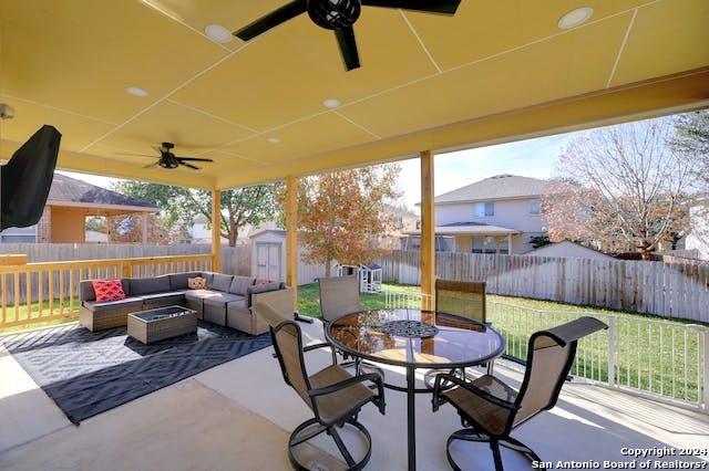 view of patio featuring a storage shed, an outdoor hangout area, and ceiling fan