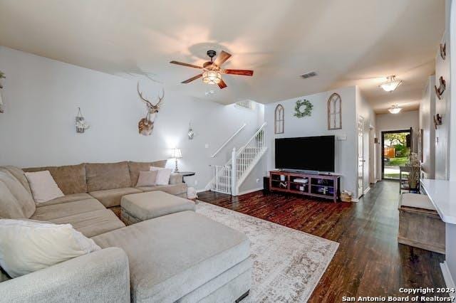 living room with ceiling fan and dark hardwood / wood-style flooring