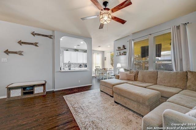 living room with sink, dark wood-type flooring, a healthy amount of sunlight, and ceiling fan