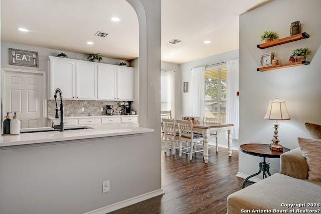 kitchen with sink, backsplash, white cabinets, and dark hardwood / wood-style flooring