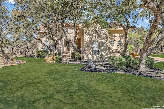 view of front of house with stucco siding and a front yard