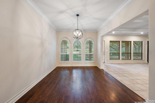 unfurnished dining area with a chandelier, hardwood / wood-style floors, baseboards, and ornamental molding