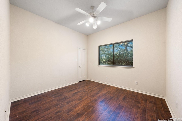 empty room featuring a ceiling fan, baseboards, and dark wood-style flooring