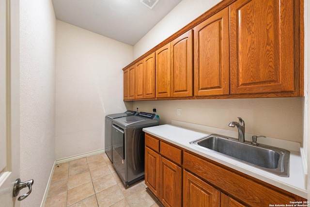 laundry area with visible vents, washer and clothes dryer, a sink, cabinet space, and baseboards
